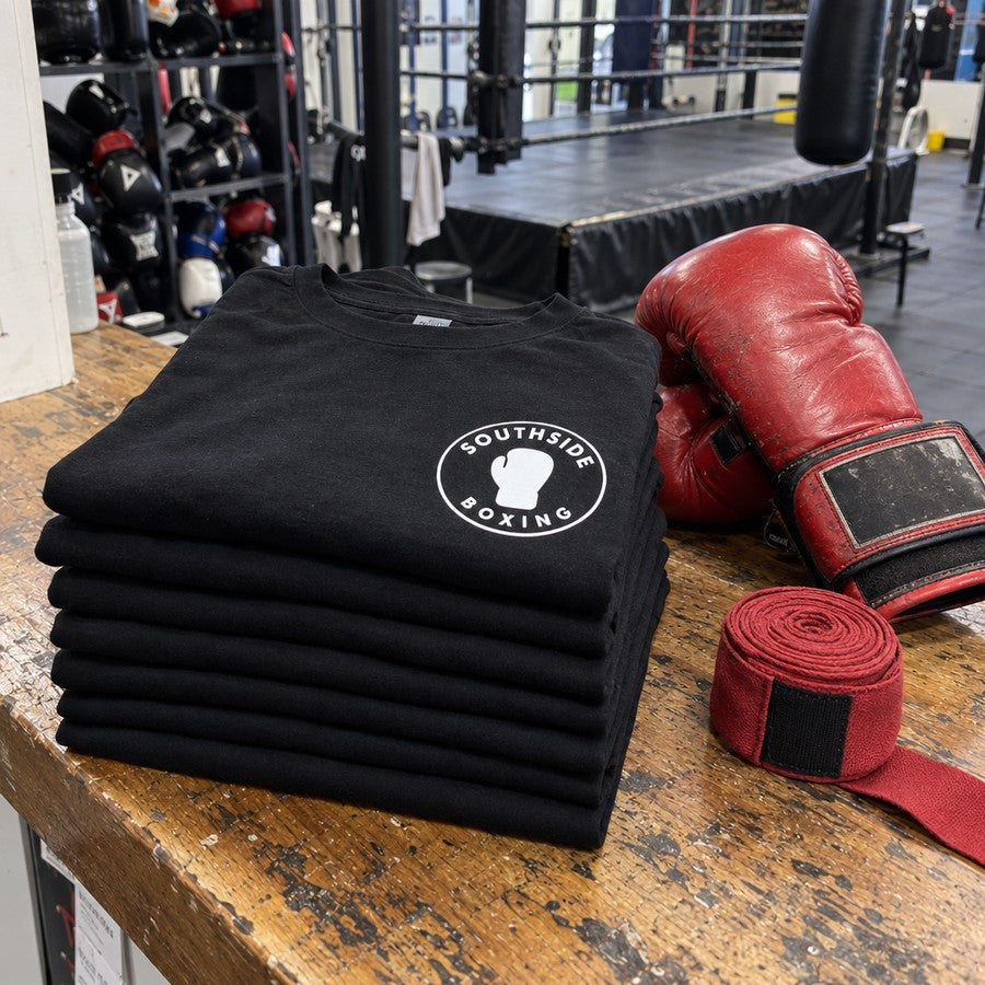 Folded gym tees on the front desk with the logo on the chest