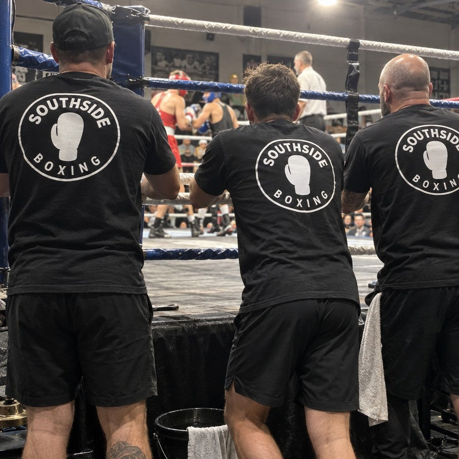 The corner at a show, three in matching gym tees with the logo on the back