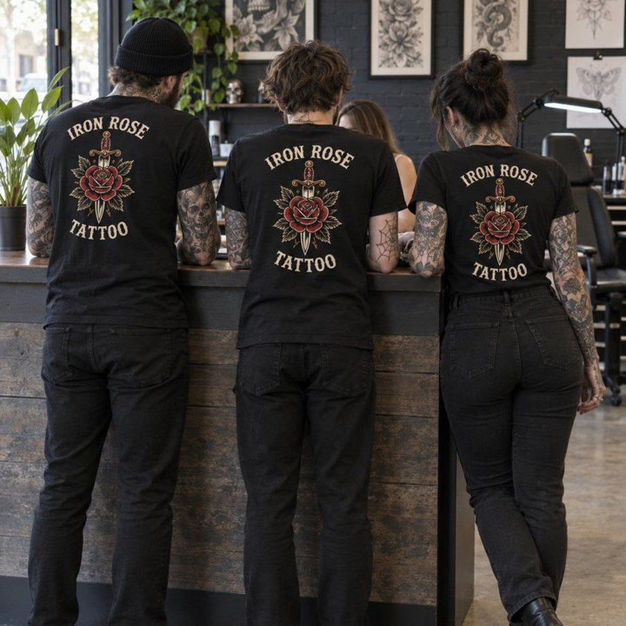 Three artists at the counter in tees with the studio design on the back